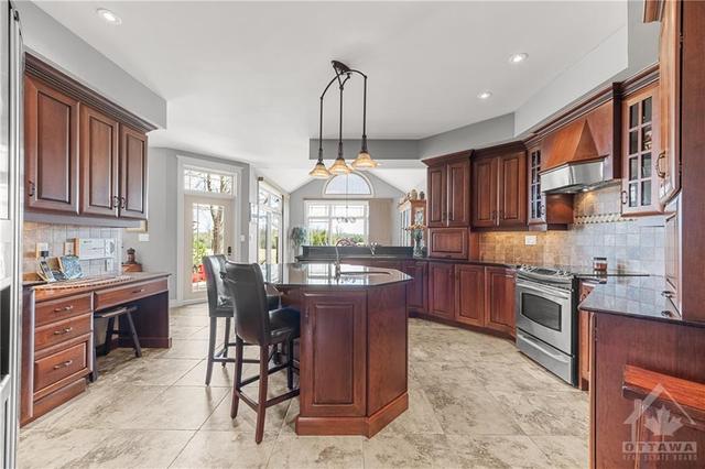 Kitchen with Large sit up Island with Sink, and tons of Custom Cherry Wood Cabinets - additional Cabinets/Pantry and Laundry Room down the Hall behind (look at link in Listing) | Image 9