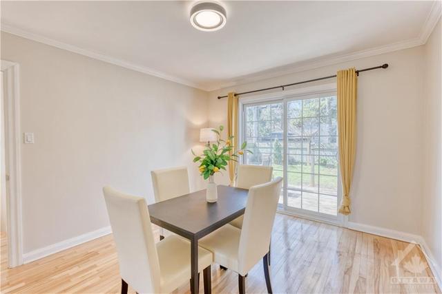 The dining room also has lovely hardwood flooring and a sliding patio door to the deck and backyard. | Image 10