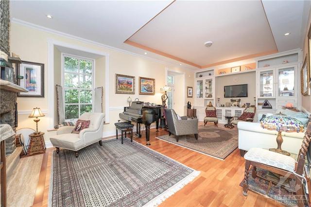 Entertainment sized living area with gorgeous hardwood floors, high ceilings, pot lights and door to back yard. | Image 7
