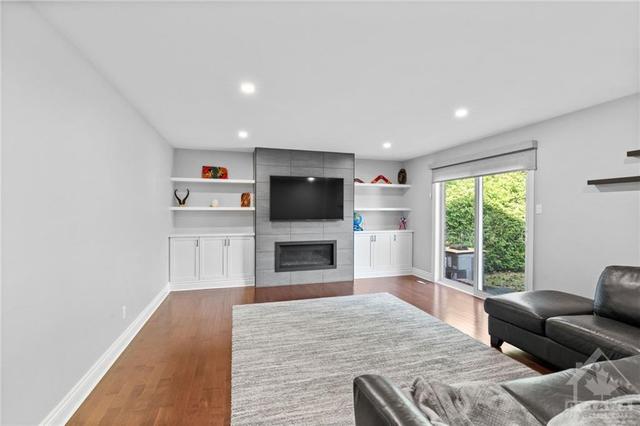 Incredible upgraded great room w/ gas fireplace & built in shelving along the back wall. | Image 13