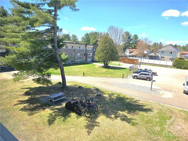 Fantastic view from the front window of this TOP FLOOR END UNIT into the Courtyard and parking lot! Lock up your bicycles, sit at the picnic table at your leisure. Distant view of the fully covere | Image 19