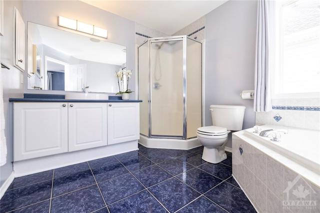 The ensuite bathroom features ceramic tiled floor, a full tub, and a walk-in shower! | Image 16