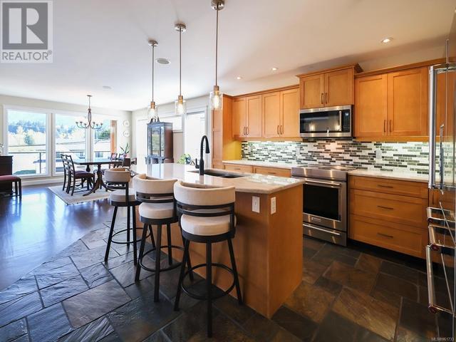 Kitchen - eat at island with quartzite countertops and new pendants | Image 15