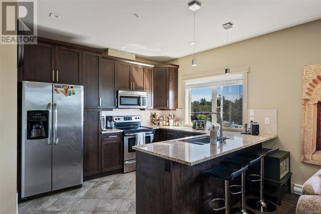 Kitchen with granite counters, tile floors, and stainless steel appliances | Image 3