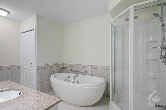 Spa-like Main BathRm with a large soaker tub, Grab Bars, corner Stand In Shower, & Vanity with Granite Counter. | Image 24