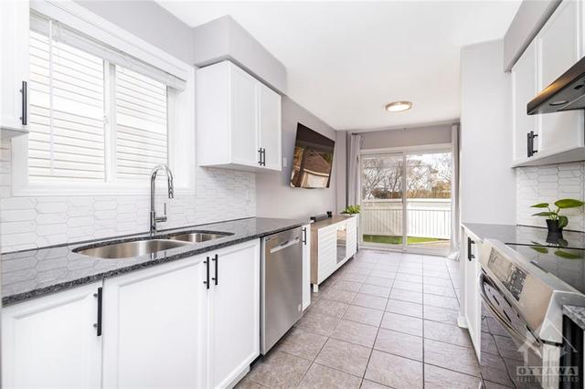 Stainless steel appliances and updated backsplash complete the spacious kitchen! | Image 8