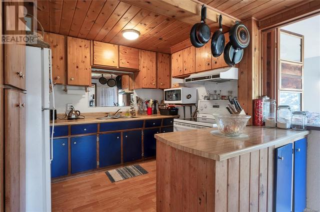 kitchen on main level, wood cabinets, butcher block laminate counters | Image 16