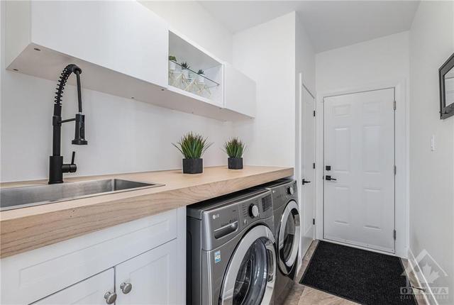Having the laundry room between the house and the garage entrance is a perfect spot to drop off work clothes for the wash, and that counter is a handy grocery drop off on the way to the kitchen. | Image 16