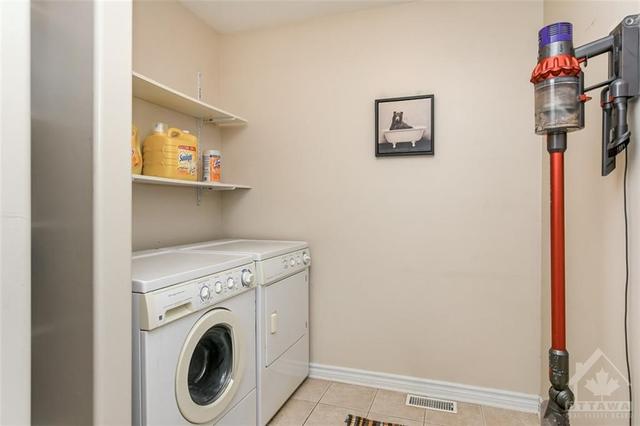 Large main level laundry room with storage shelves. | Image 21