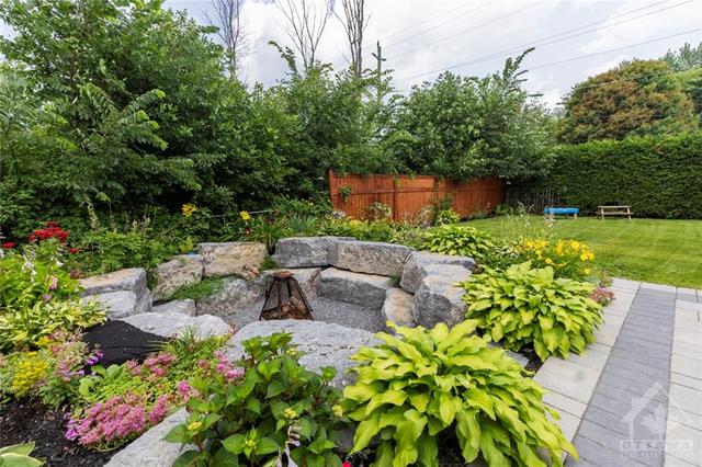 Beautiful sunken armour-stoned fire pit, surrounded by greenery | Image 16