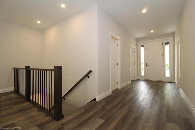 Front foyer with the wooden railing going to the lower level. Laminate flooring | Image 48