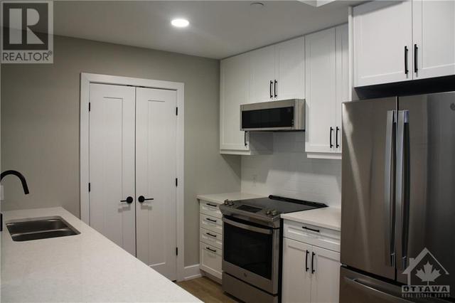 Galley kitchen with hidden laundry at the end (from unit with reverse floor plan) | Image 1