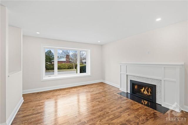 Living room features a gas fireplace. Beautiful hardwood floors. Picturesque window. | Image 6