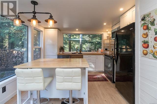 Beautiful renovated kitchen with oversized window, natural wood countertops, stainless steel appliances and modern fixtures | Image 11