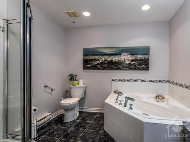 Spacious ensuite with soaker tub, corner shower stall and ceramic tile flooring! | Image 19