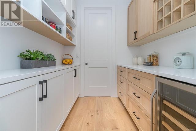 Walk through double sided pantry w/real wood cabinetry and wine cooler | Image 26