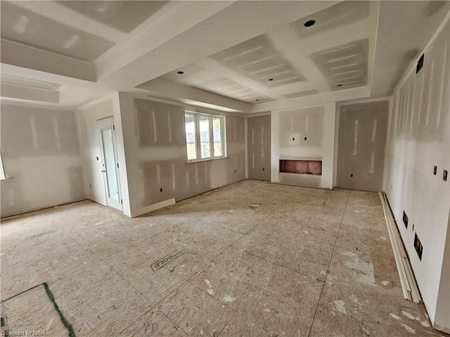 Living room with tray ceilings & electric fireplace. | Image 4