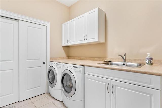 main floor laundry with sink and inside entry to the garage | Image 22