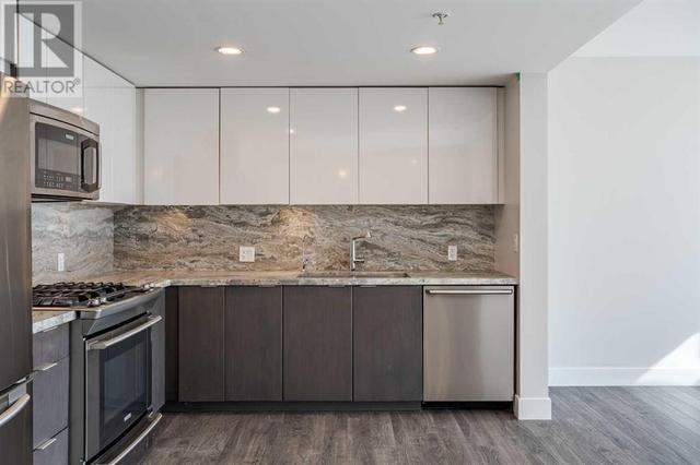 Open concept with granite, backsplash and upgraded appliances including gas stove | Image 6