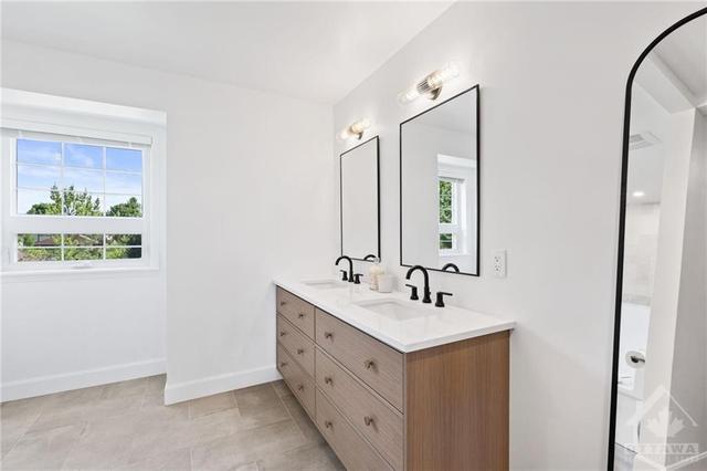 The primary suite features a lavish bathroom with herringbone tile, a custom white oak (grain matched) floating vanity with double Pearl sinks and a walk in shower (shower and floors waterproofed | Image 17