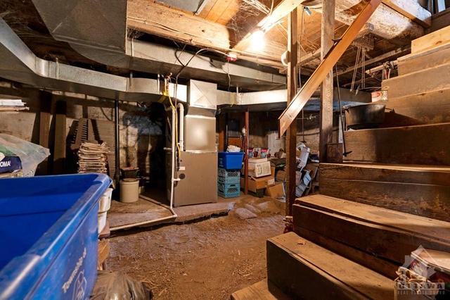 Basement has utility area plus workshop with woodstove and outside door | Image 24