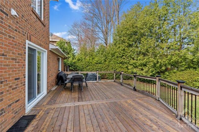Backyard hosting oasis with fully fenced deck that has a gate and steps down to the grass. | Image 29