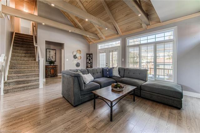 The open-plan living/kitchen/dining area is crowned by an impressive vaulted beam ceiling, with triple-aspect windows that bathe the space in natural light. | Image 4