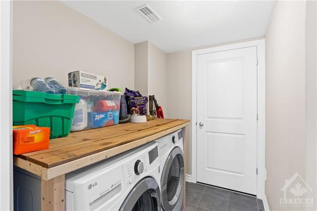 Tiled laundry room with walk-in seasonal storage room through the doors. | Image 7