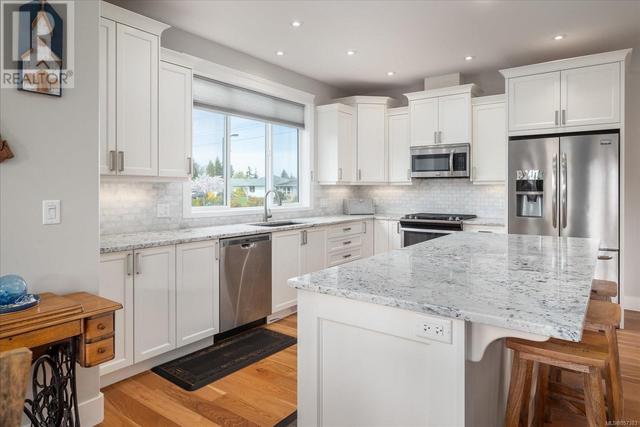 An amazing kitchen features Stainless Whirlpool and Frigidaire appliances, gas range and LOTS of granite counter space, tile backsplash and a sit and visit island thats over 7ft in length. | Image 3