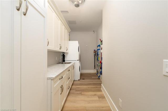 Large pantry/laundry with a vented and stacked Whirlpool washer and dryer and Enns custom cabinets | Image 32