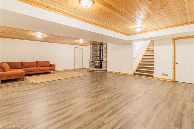 This massive family room / rec room over brand new flooring features a knotty pine ceiling & the 3rd of 3 fireplaces, this one being a wood burning unit. | Image 30