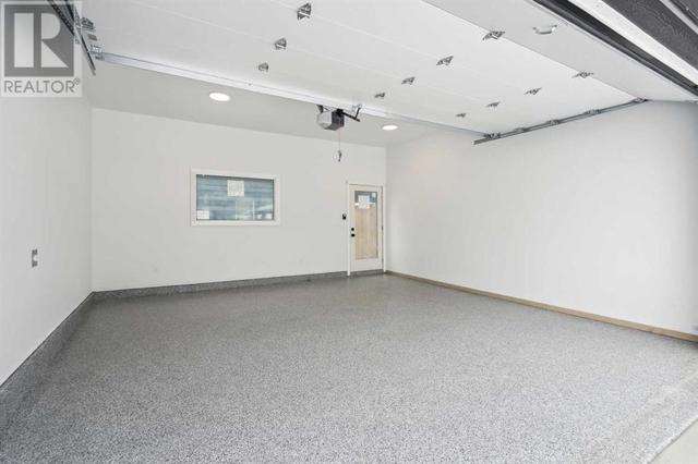 The insulated double garage features epoxy floors and is complete with insulation and electric vehicle charging station | Image 48