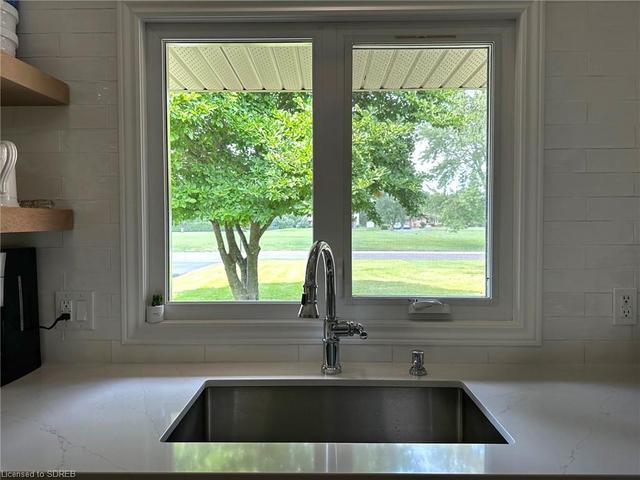 Window over the sink has view of Park across the road. | Image 11