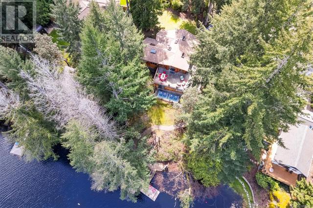 Drone photo of the back of the house showing the large deck and very private lot | Image 4