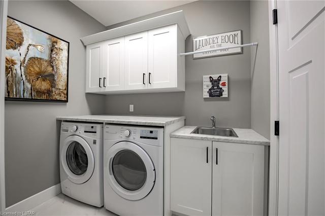 Side by side washer/dryer w/ folding counter, utility sink & built-in cabinetry. | Image 19