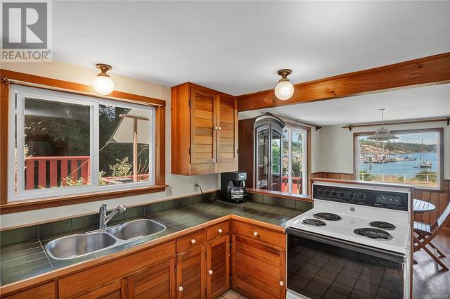 kitchen on upper main floor - tile counters & wood cupboards | Image 23
