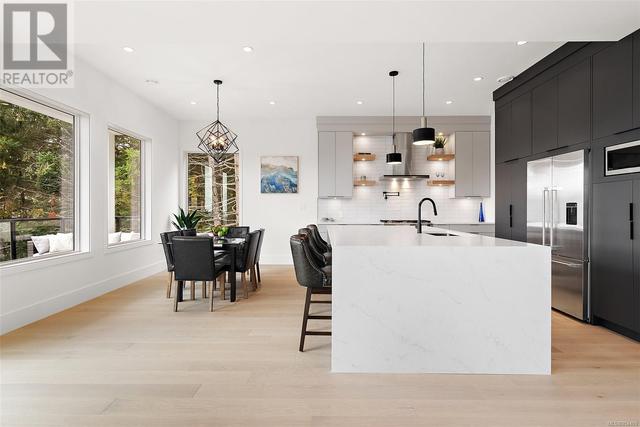 Kitchen with quartz waterfall island and countertops. | Image 6