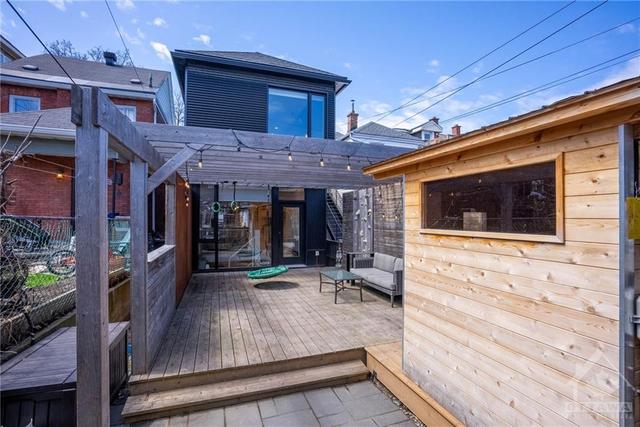 View of the backyard, large deck with monkey bars, rock wall and swing. This eastern facing yard is perfect for your morning coffee. | Image 30
