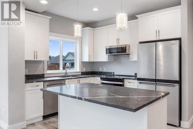Kitchen with quartz countertops and a complete stainless steel appliance package | Image 10
