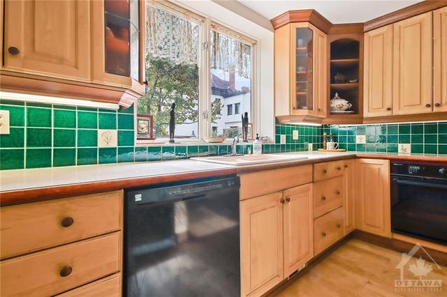 Renovated Kitchen with some show case cabinets, crown mouldings, valance lighting. Sink overlooks rear garden/fenced yard. | Image 10