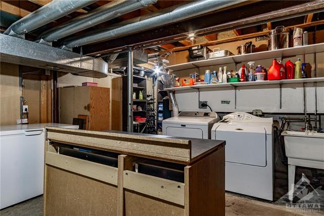 utility room offers storage, furnace, workbench | Image 21