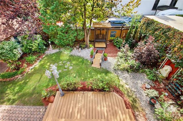 Rear terrace/balcony overlooks the fenced tranquil garden/yard with sitting patio area. | Image 22