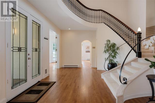 Achoring the home in sophisticated elegance, the grand dual staircase showcases a soaring ceiling. | Image 11