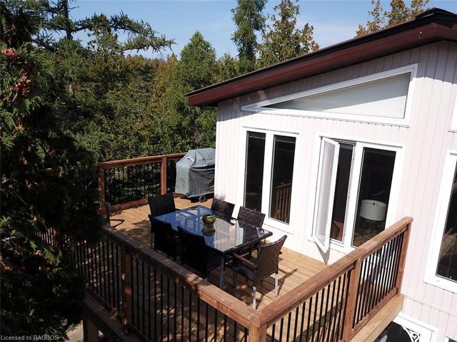 Exterior of the home is low maintenance with vinyl windows and siding, steel roof and concrete patio and walkways. | Image 21