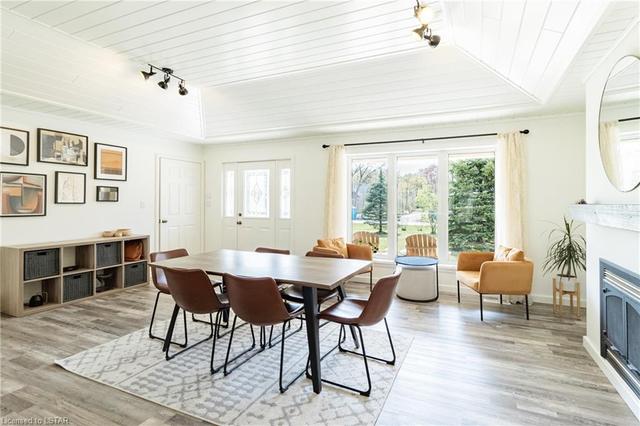 The vaulted white shiplap ceiling & full walls of windows on both sides of the room provide an abundance of natural light. Also note the gas fireplace, one of 3 fireplaces in this superb home. | Image 6
