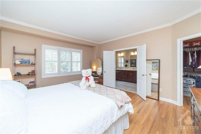 The large primary bedroom features gleaming hardwood, a massive walk-in closet and a gorgeous luxury ensuite. | Image 14