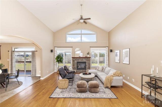 Gorgeous, bright living room flooded with natural light featuring a gas fireplace and vaulted ceilings. | Image 5