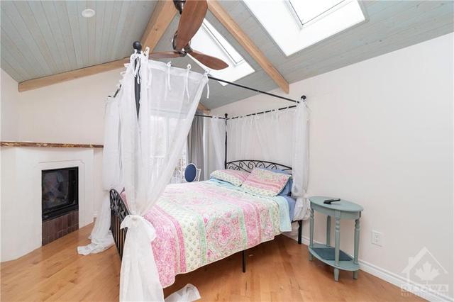 Primary Bedroom with skylights and gas fireplace | Image 15