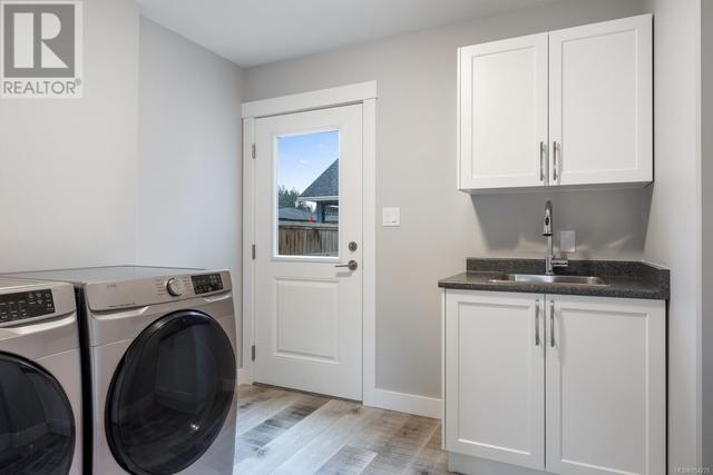 Laundry room, backyard access, stainless steel sink, complete with a washing machine and dryer | Image 15