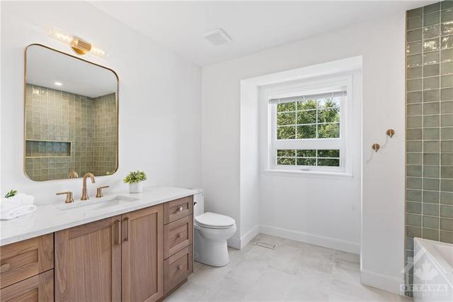 The second floor bathroom features a custom white oak vanity with Silestone quartz, a modern oversized soaker tub and a timeless handmade green tile. (Shower and floors waterproofed with Schluter® | Image 20